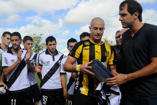 Pablo Lima recibe la plaqueta de manos de Jadson Viera, capitán de Danubio.