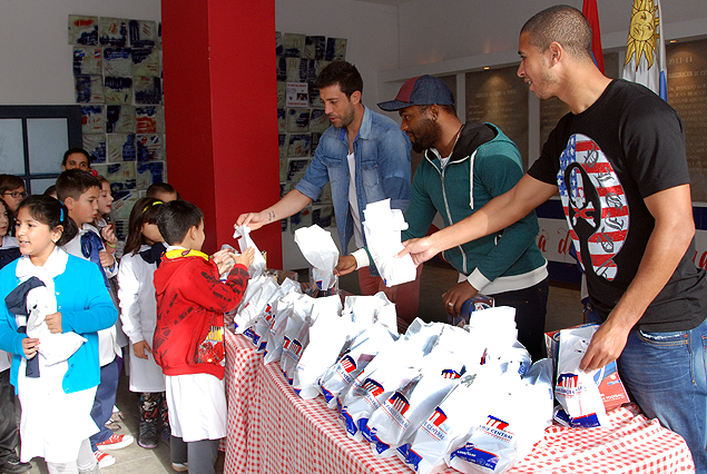 Jorge Bava, "Morro" García y Diego Arismendi le dan la merienda a los niños tricolores.