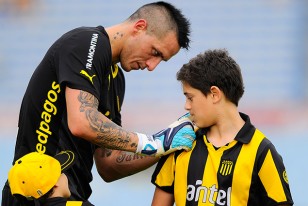 "No hemos cumplido los objetivos y eso duele", dijo Pablo Migliori que en la fotografía deja estampada su firma en la camiseta de un pequeño hincha aurinegro. 